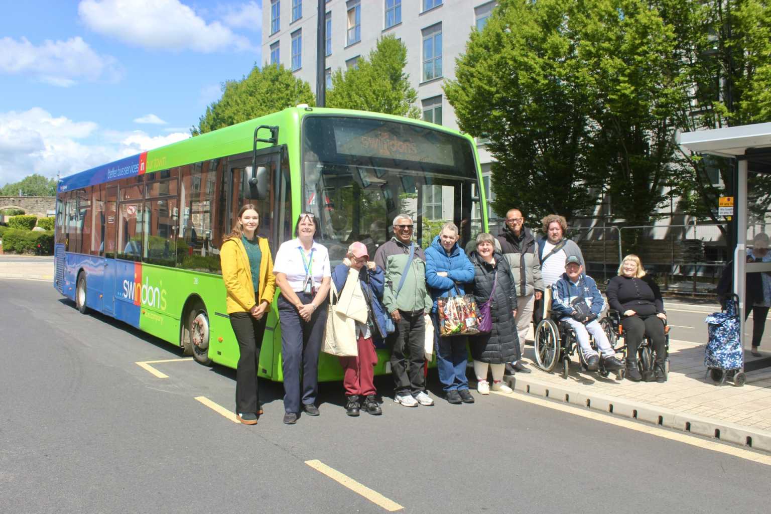 A swindon's bus company bus with people a group of swindon's bus company team members and local people with learning disabilities